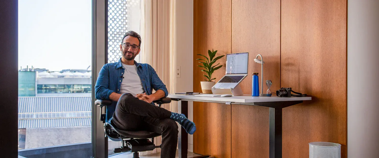 Ali sitting at his desk in his new apartment